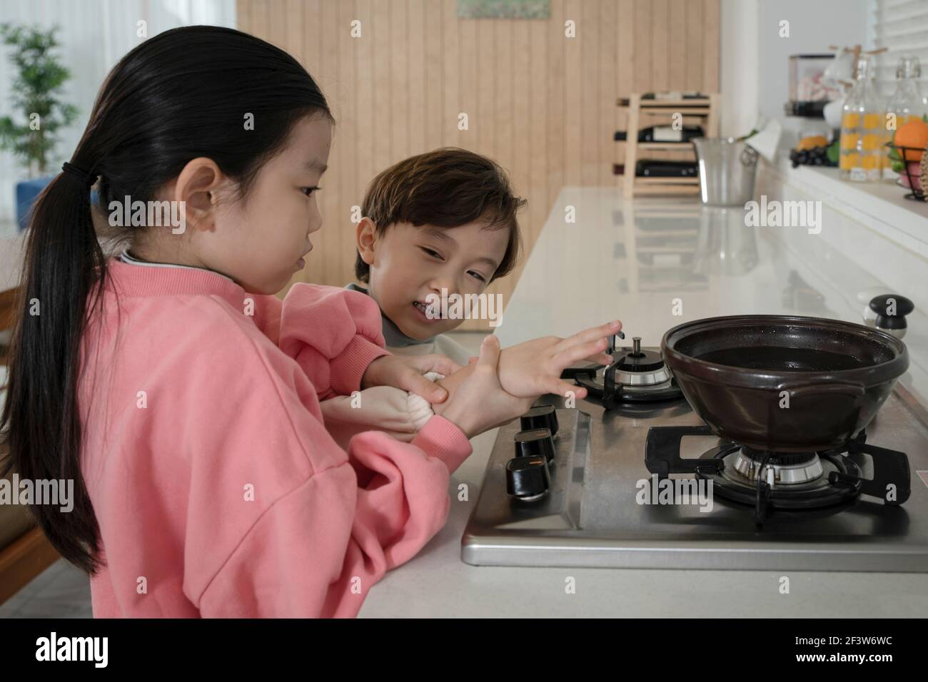 Kindesmissbrauch Konzept, asiatische Kinder versuchen zu kochen Stockfoto