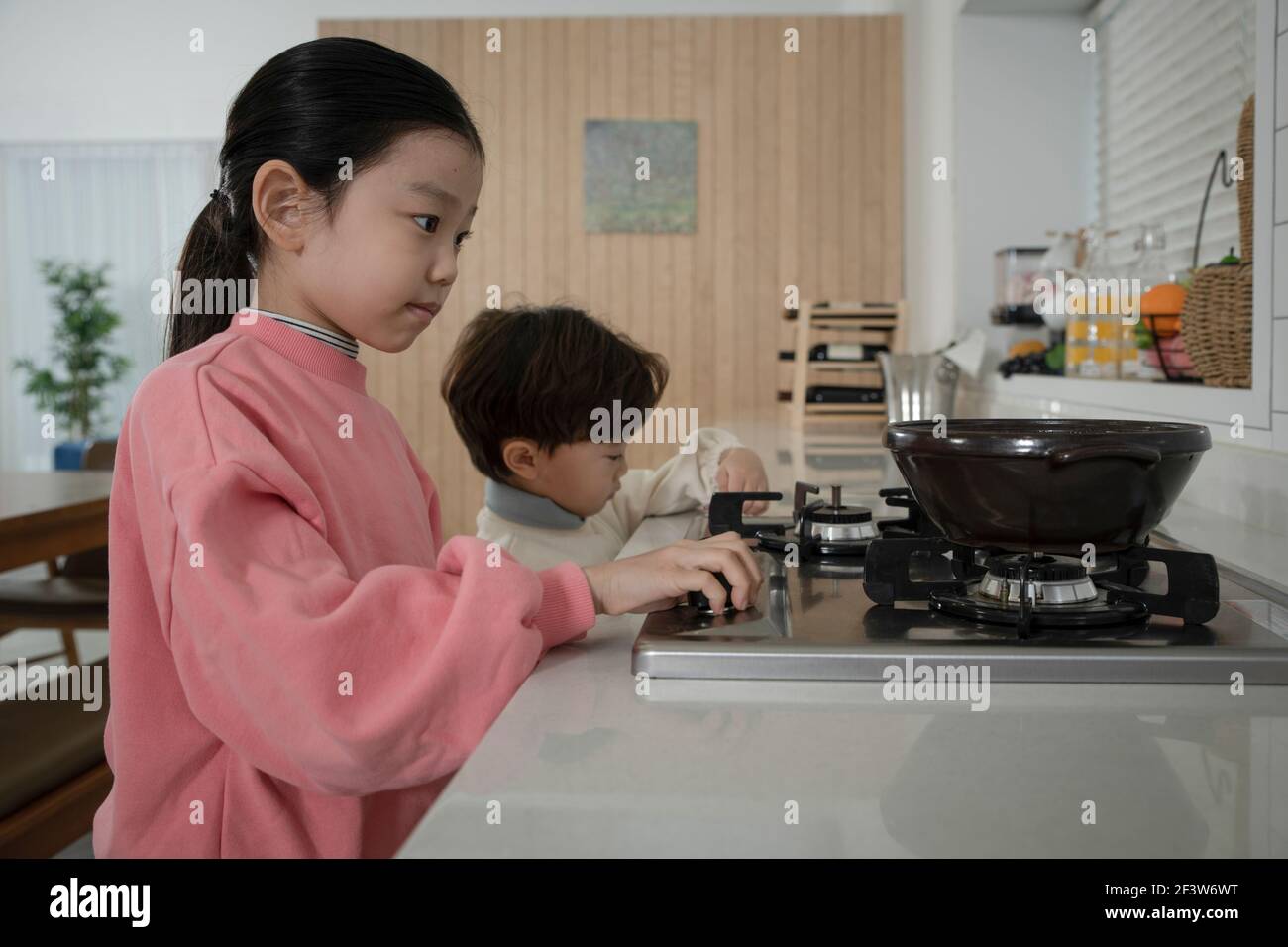 Kindesmissbrauch Konzept, asiatische Kinder versuchen zu kochen Stockfoto