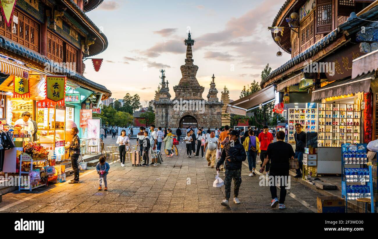 Kunming China , 4 October 2020 : schöne malerische Straße Blick auf Guandu Altstadt mit alten Jingang Pagode Menschen und bunten Geschäften bei Sonnenuntergang in Ku Stockfoto