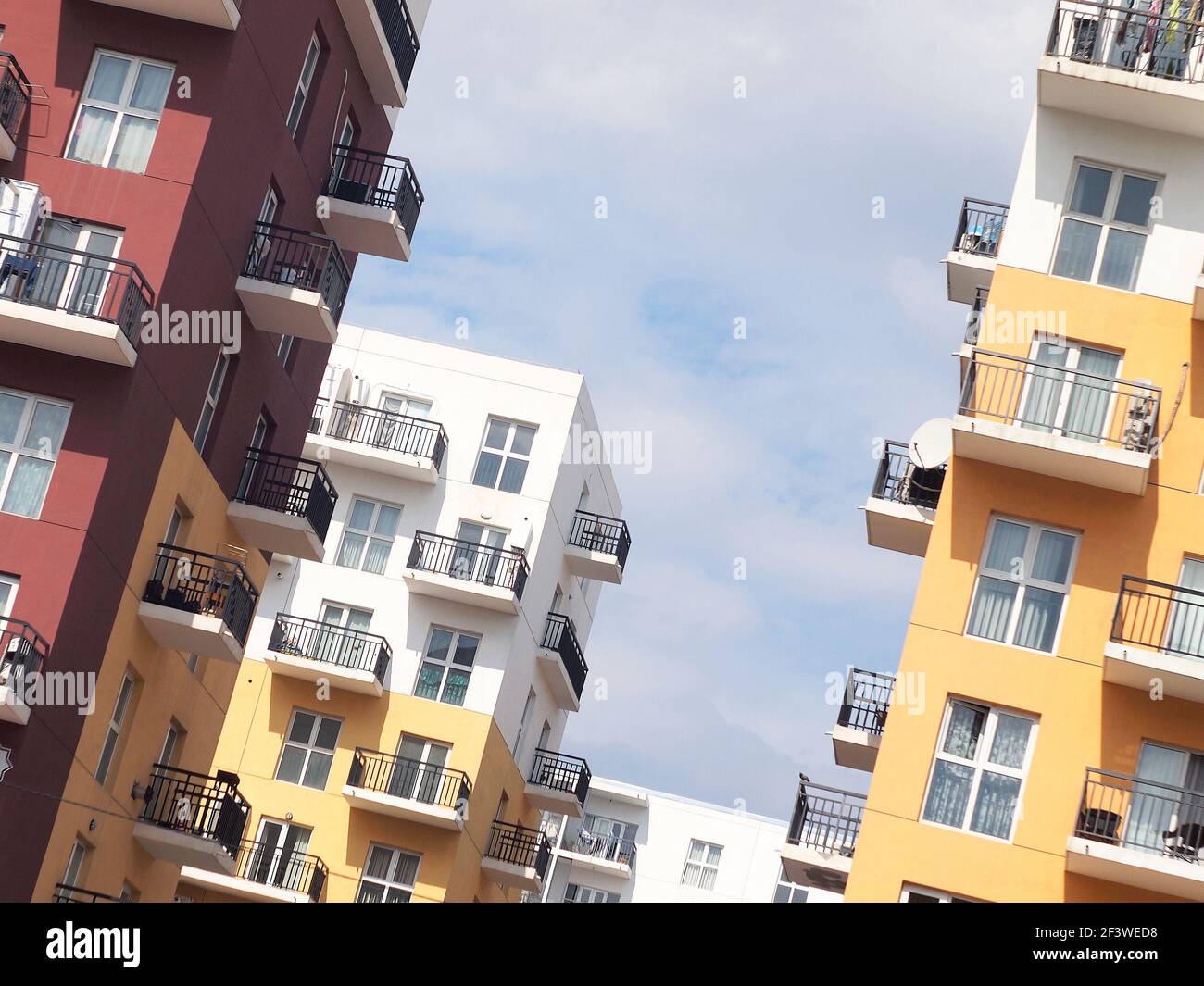 Bunte Wohnblöcke mit schlichtem Design. Wohngebäude in weiß, rot und gelb. Stockfoto