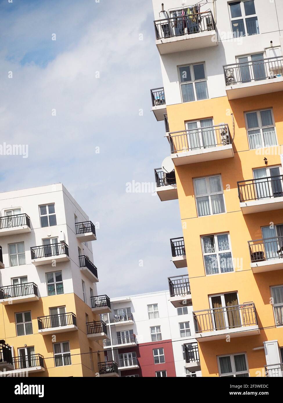 Bunte Wohnblöcke mit schlichtem Design. Wohngebäude in weiß, rot und gelb. Stockfoto