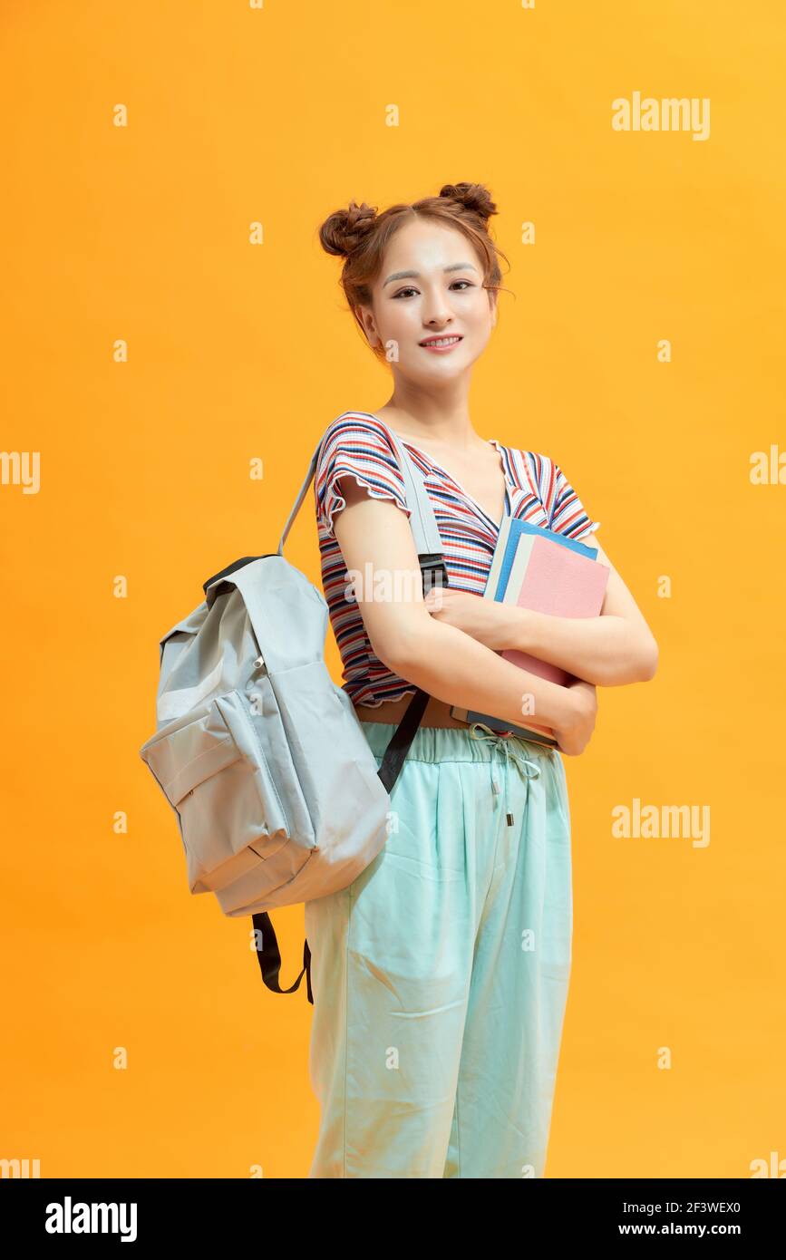 Glücklich weibliche College-Student auf gelbem Hintergrund Stockfoto