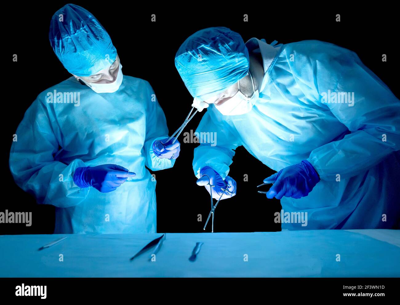Zwei Neurochirurgen-Ärzte, eine Frau und ein Mann führen eine komplexe Operation durch. Konzept der Kategorie der Komplexität und Dauer der Operationsopera Stockfoto