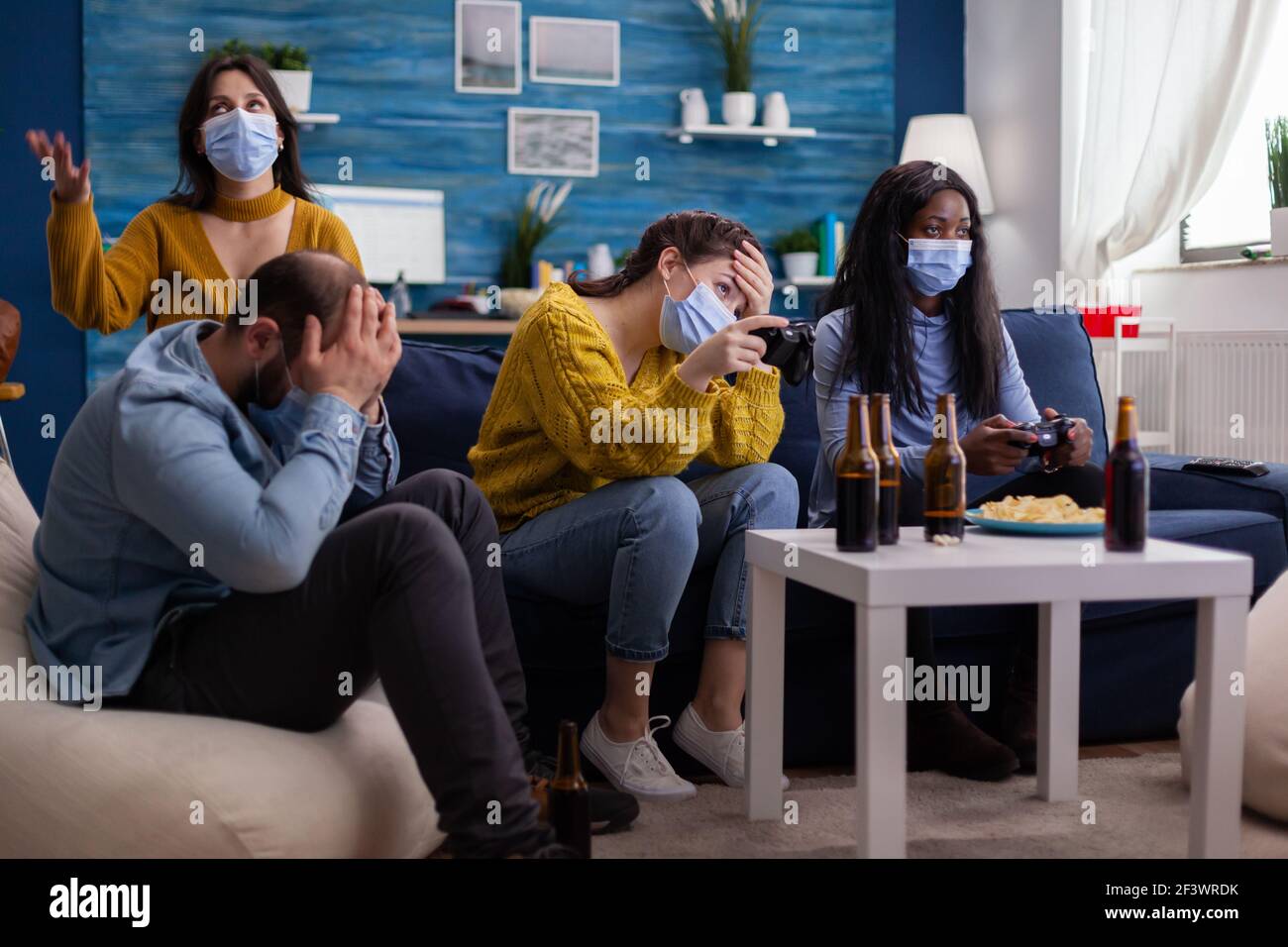 Enttäuscht verschiedene Menschen verlieren Videospiele zu Hause Respekt soziale Distanzierung wegen der Corona Ausbruch tragen Gesichtsmaske gegen die Verbreitung von Virus. Neue normale Partei soziale Distanz Stockfoto