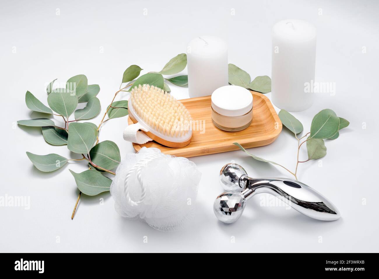 Gesichtswalze, Massagebürste, Gesichtscreme, Waschlappen und Kerzen mit natürlichen  Eukalyptusblättern auf hellem Hintergrund. Beauty-Produkte, Massage-Werkzeuge,  fa Stockfotografie - Alamy