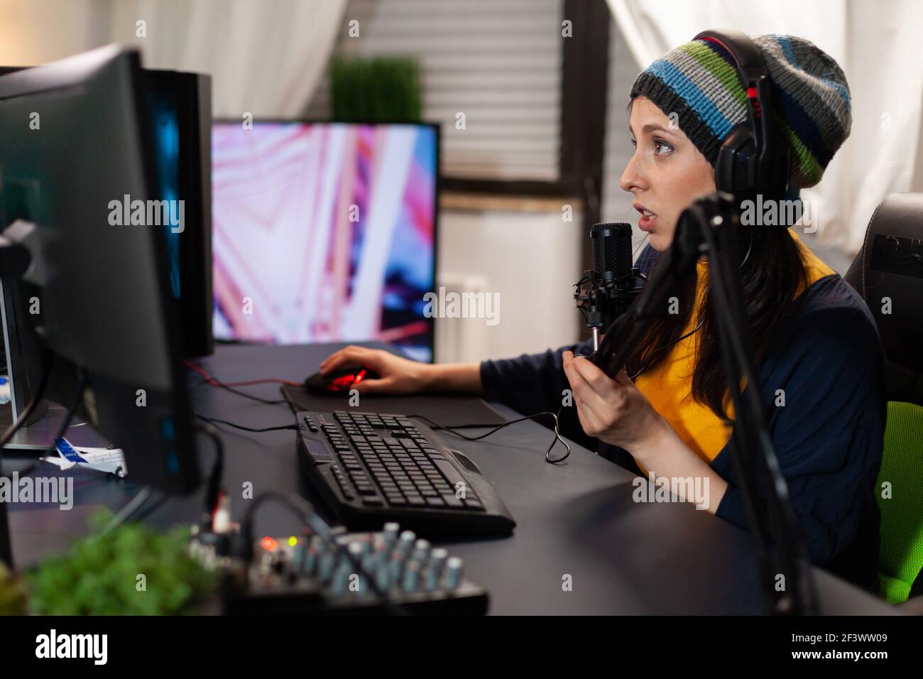Kaukasischen pro Streamer im Gespräch in professionelle Mikrofon für virtuelle Konkurrenz in Gaming-Home-Studio. Gamer spielen Online-Videospiele mit neuen Grafiken auf leistungsstarken Computer Stockfoto