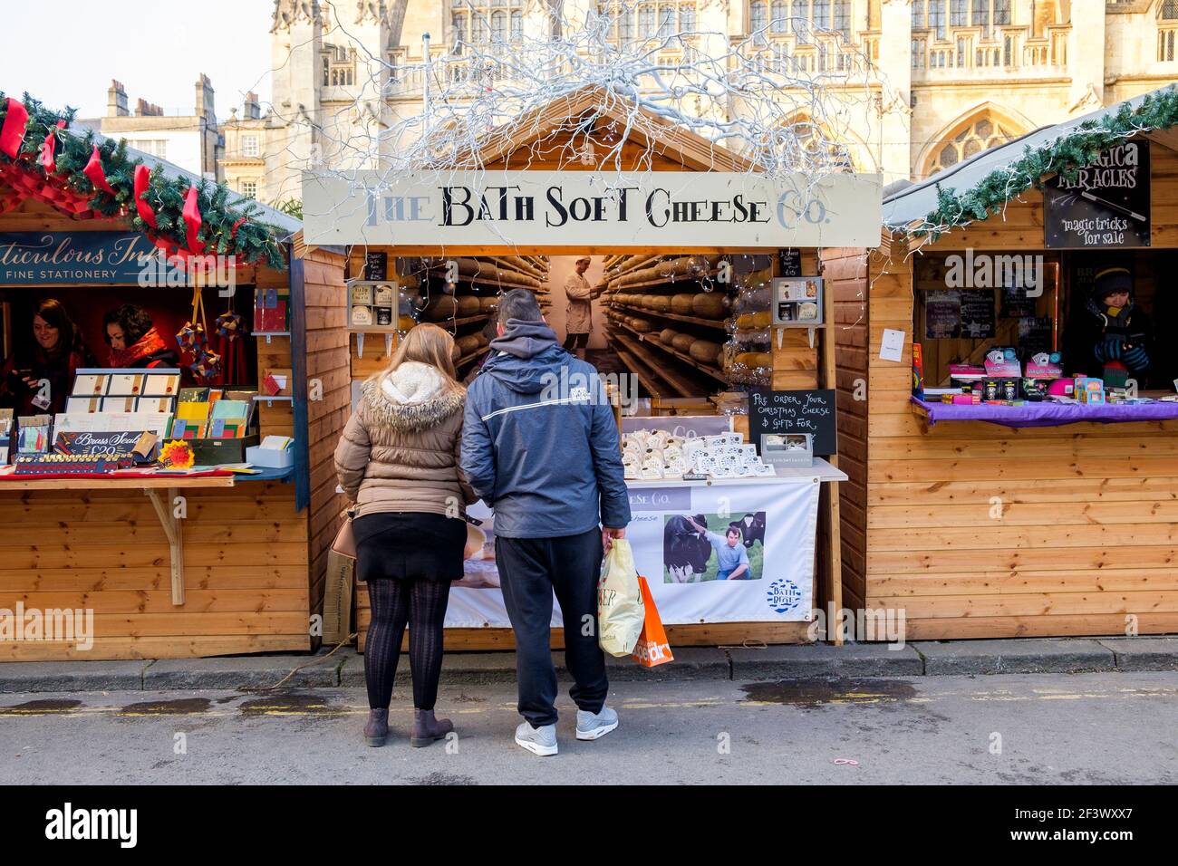 Die Käufer werden beim Besuch des Weihnachtsmarktes in Bath abgebildet.jedes Jahr befinden sich in den Straßen rund um die römischen Bäder und die Abtei von Bath über 150 Chalets. Stockfoto
