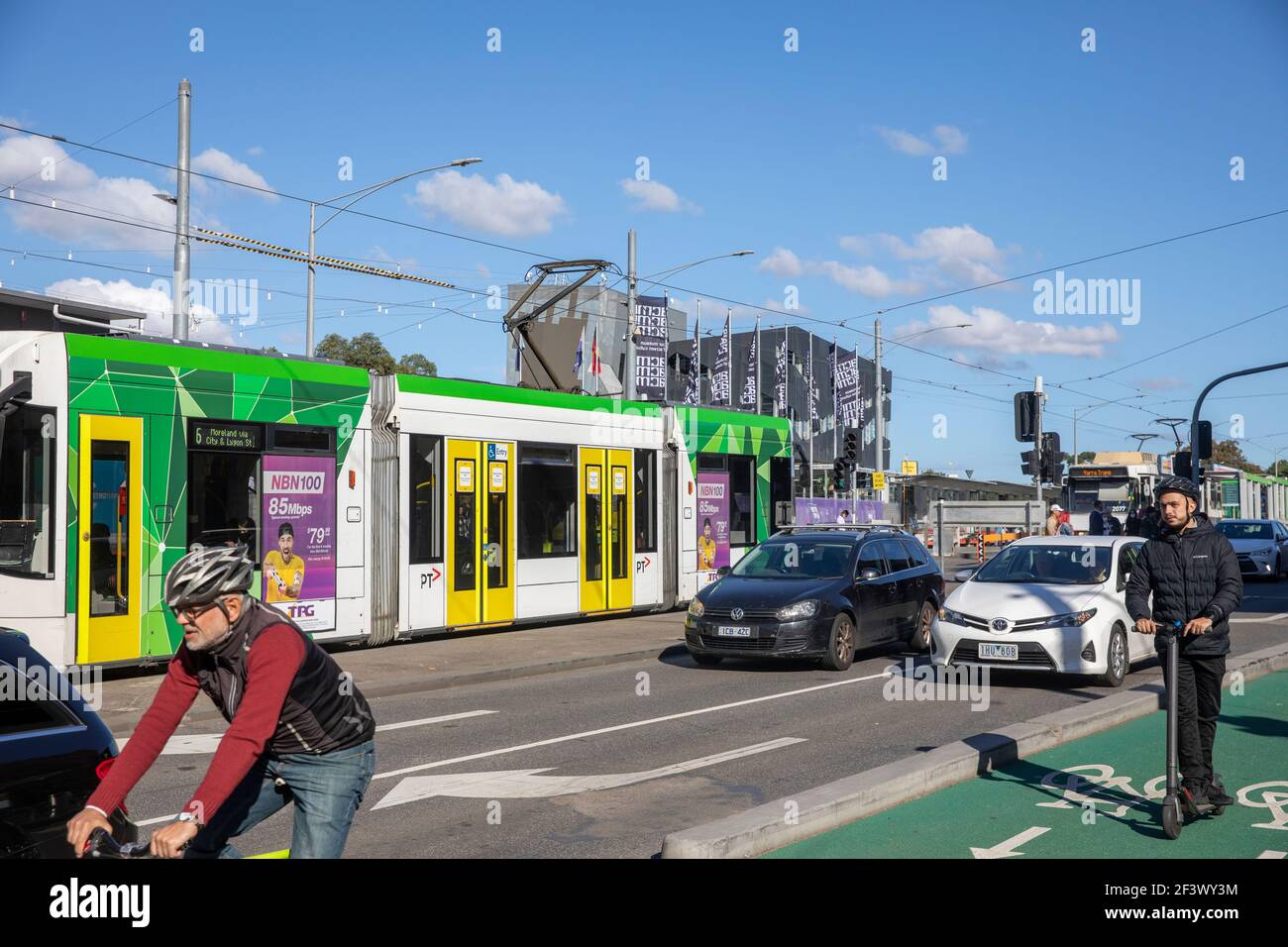 Melbourne City Centre verschiedene Verkehrsmittel, Straßenbahn, Fahrrad, Elektroroller und Auto, Australien Stockfoto