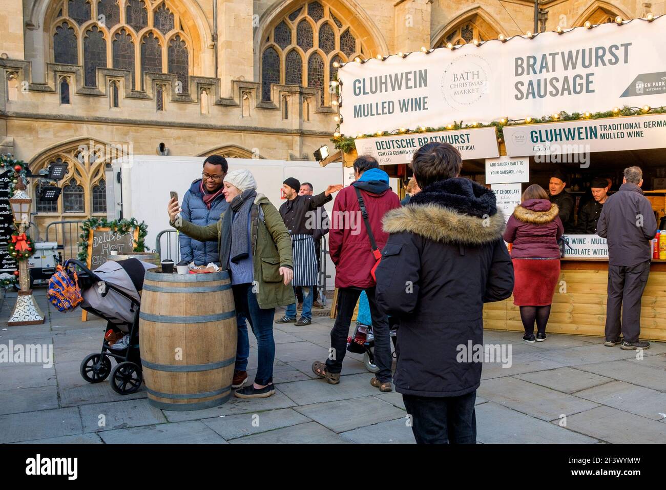 Die Käufer werden beim Besuch des Weihnachtsmarktes in Bath abgebildet.jedes Jahr befinden sich in den Straßen rund um die römischen Bäder und die Abtei von Bath über 150 Chalets. Stockfoto