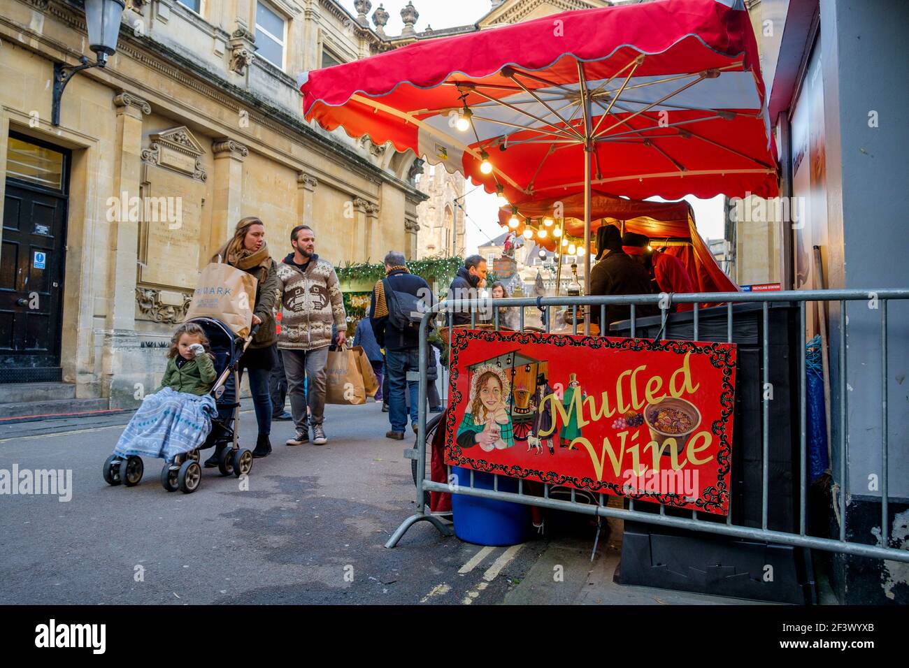 Die Käufer werden beim Besuch des Weihnachtsmarktes in Bath abgebildet.jedes Jahr befinden sich in den Straßen rund um die römischen Bäder und die Abtei von Bath über 150 Chalets. Stockfoto