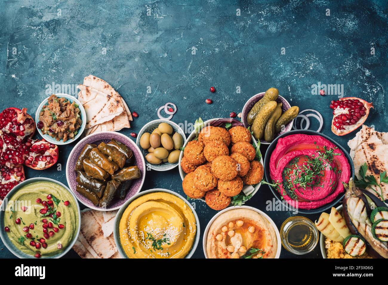 Traditionelle Nahost sortierte Meze: Hummus, Pita, Oliven, Pistazien, Dolma, Falafel Bälle, Gurken, Babaganush, Gemüse, Granatapfel Stockfoto