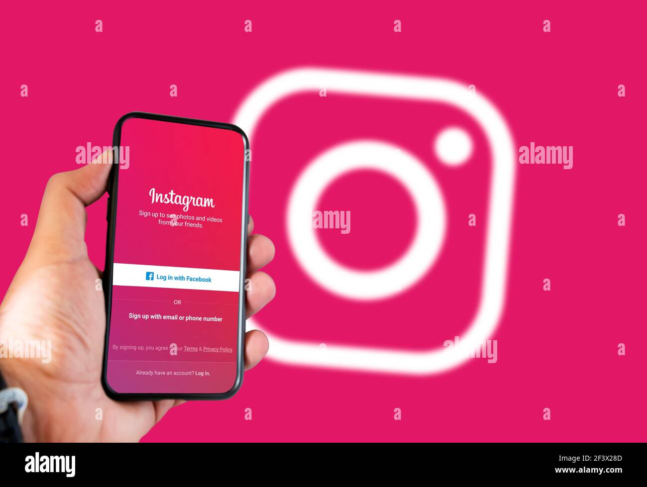 Rom, Italien, februar 16th 2021: Hand hält ein Smartphone mit Instagram Social App Login-Seite auf dem Bildschirm und verschwommen Instagram Logo auf dem Hintergrund. So Stockfoto