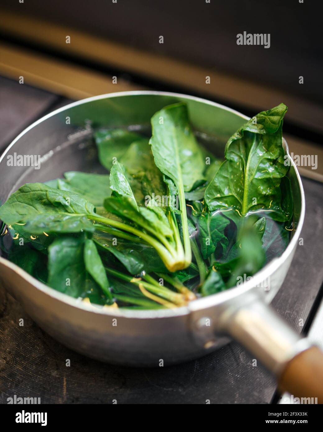 Frische grüne Spinatblätter in einer kochenden Pfanne Stockfoto