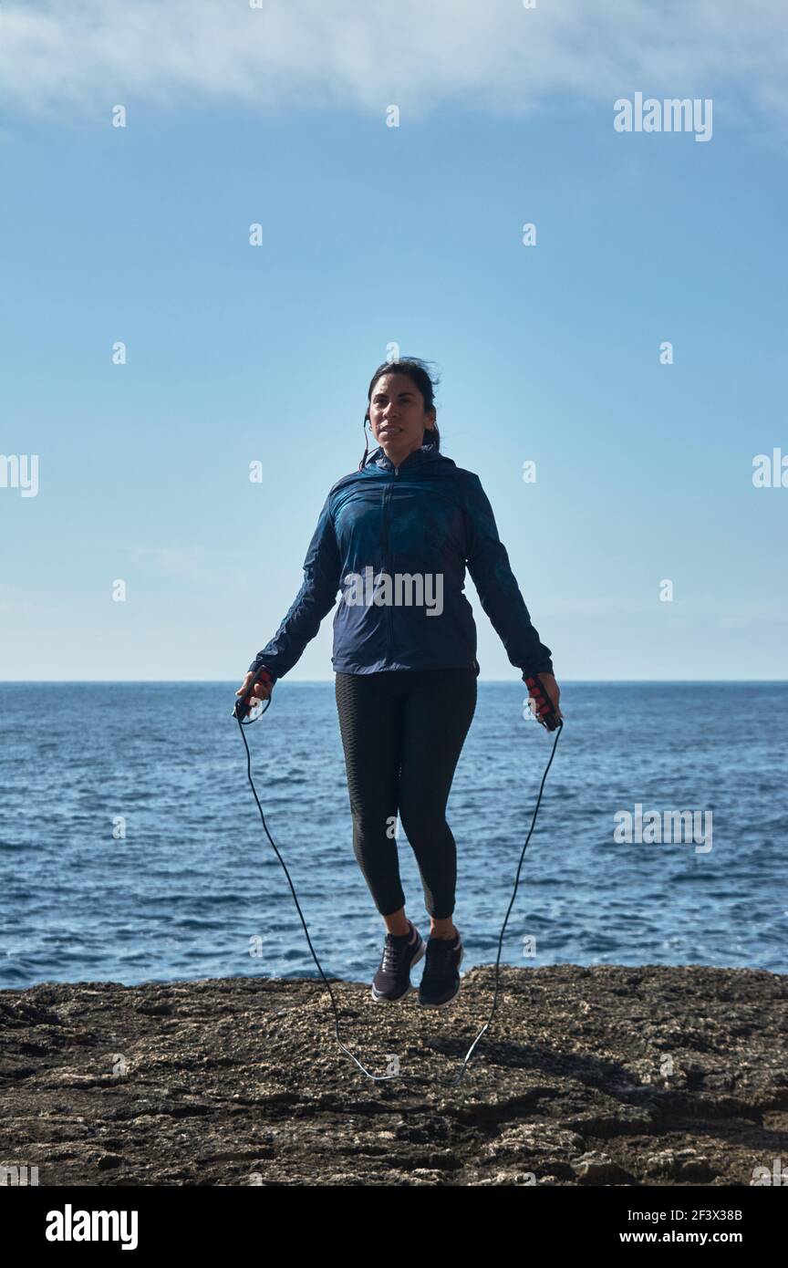 Latinerin, mittleren Alters, trägt Sportkleidung, Training, macht körperliche Übungen, Plank, Sit-Ups, Kletterschritt, Kalorien verbrennen, fit bleiben, Übertrumpfer Stockfoto