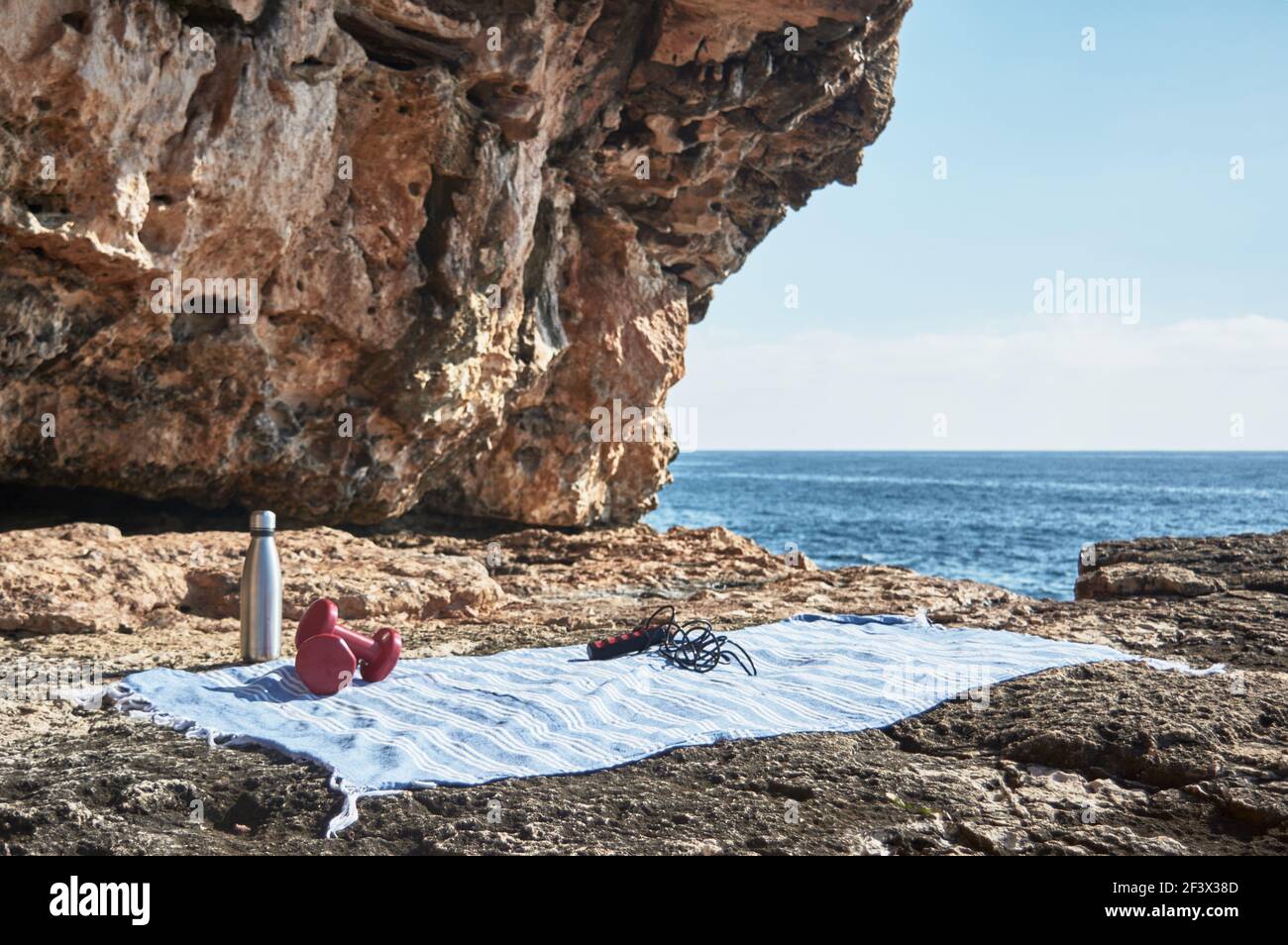 Fitness und Sport Konzept Hintergrund. Machen Sie sich fertig. Handtuch, Springseil, Hantel und Flasche Wasser, am Meer an einem sonnigen Wintertag, mit schönen Stockfoto