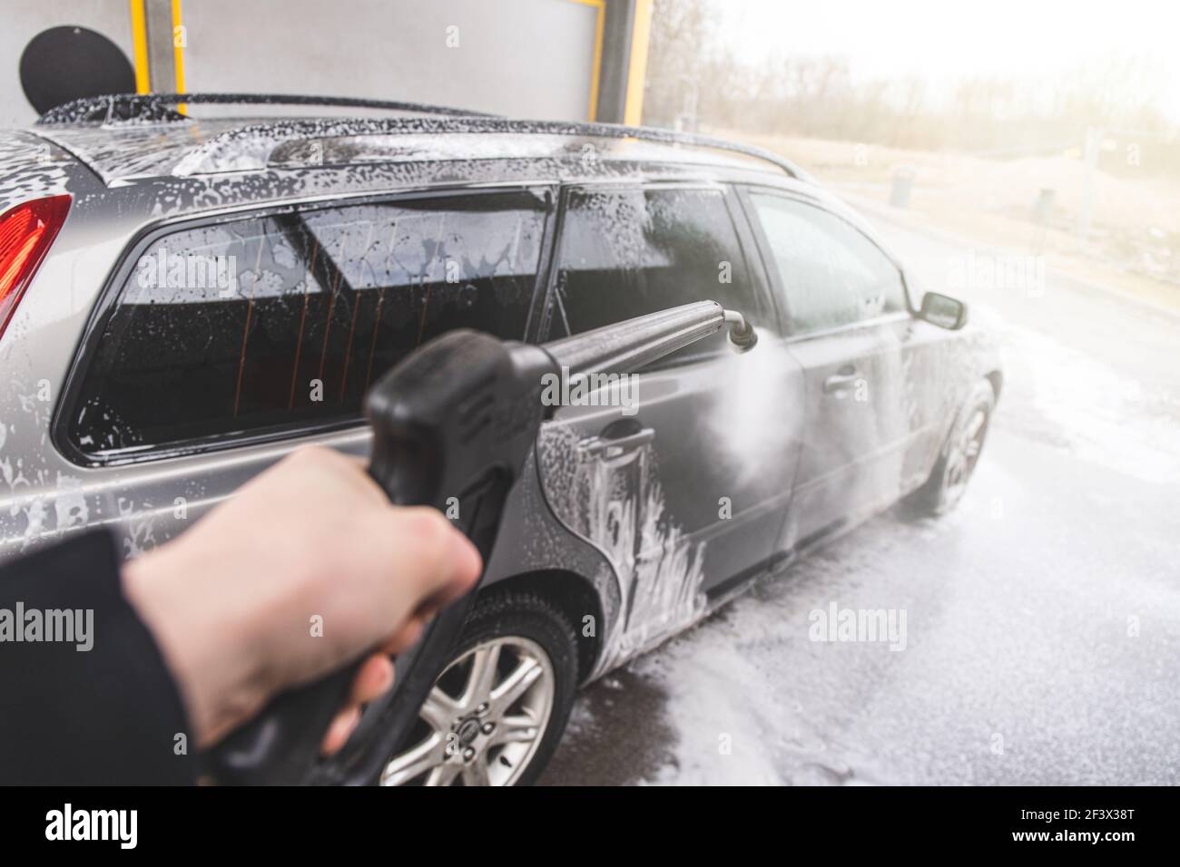 Kontaktloses Autowaschsystem. Schmutziges Auto in der Waschanlage mit Schaum waschen Stockfoto