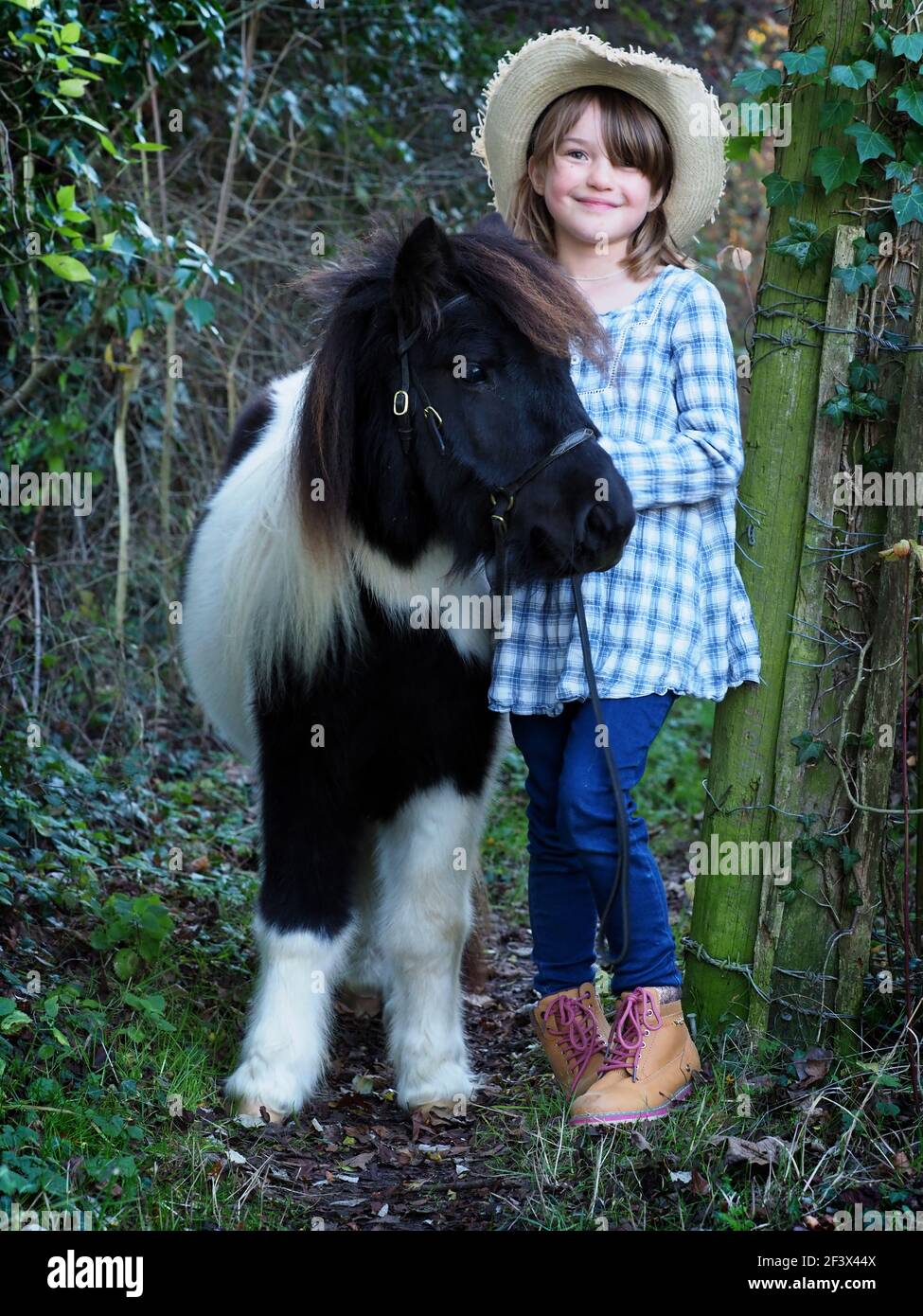 Ein Mädchen draußen mit ihrem schwarz-weißen Pony Stockfoto