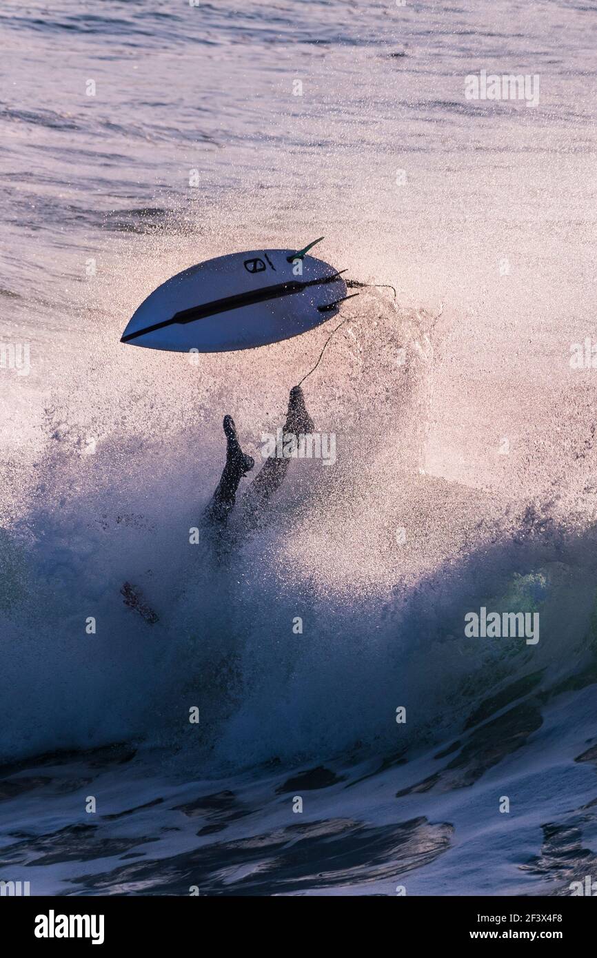 Ein Surfer, der auf einer wilden Welle am Fistral in Newquay in Cornwall auswischt. Stockfoto