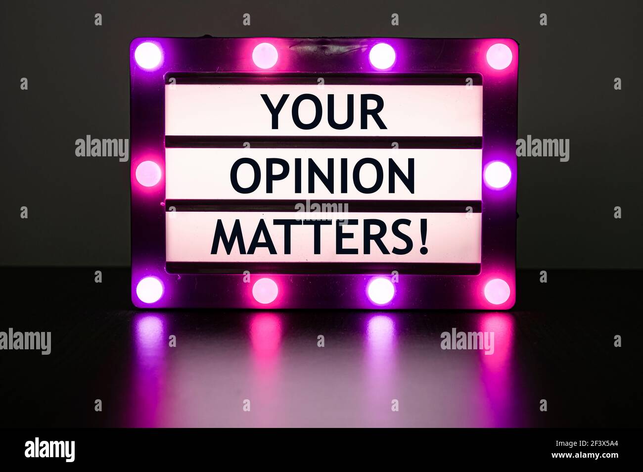 Leuchtkasten mit pinken Lichtern mit Wörtern - Ihre Meinung zählt! Stockfoto
