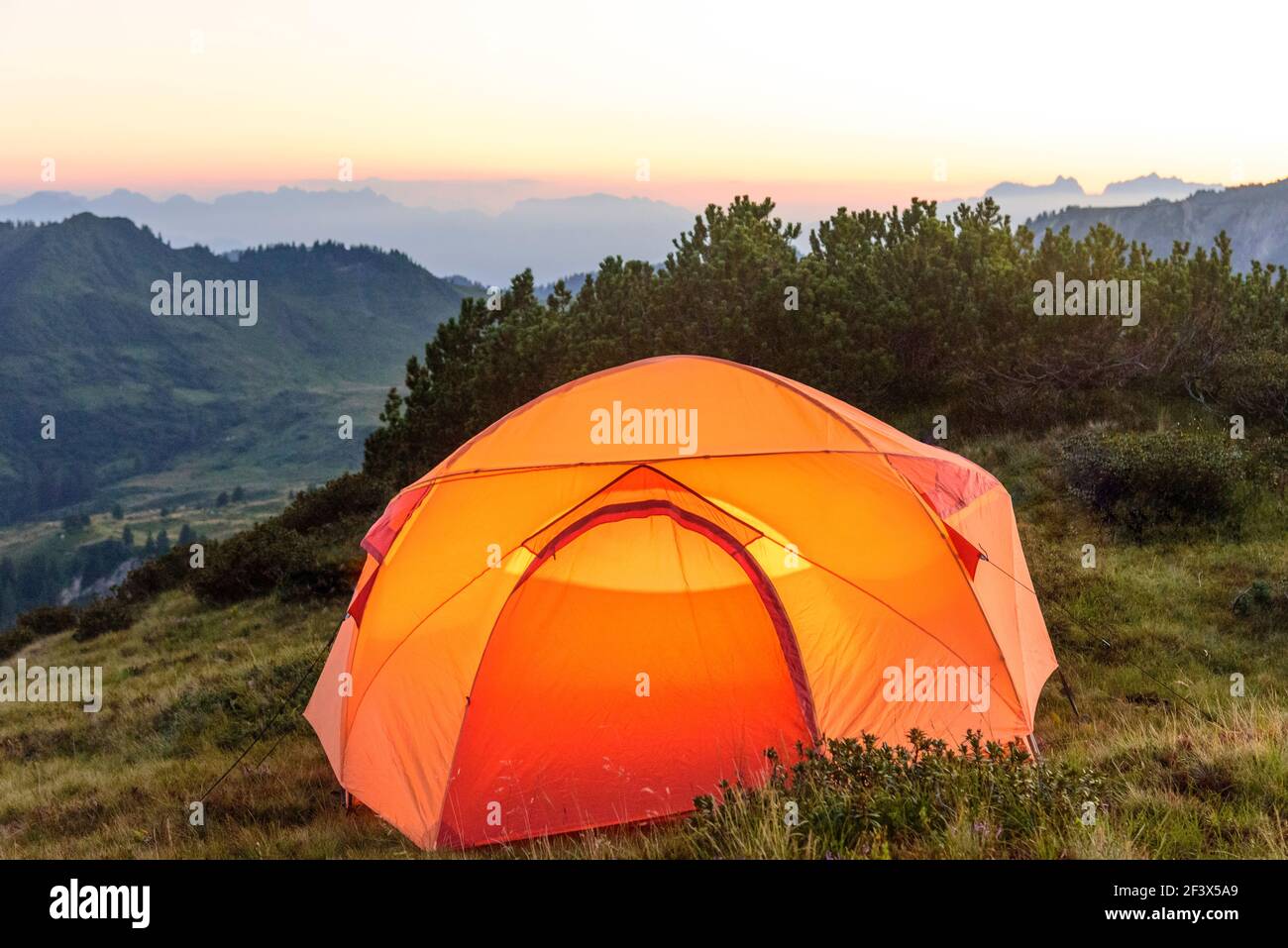 Beleuchtetes Zelt in den Abendstunden in den Vorarlberger Bergen Stockfoto