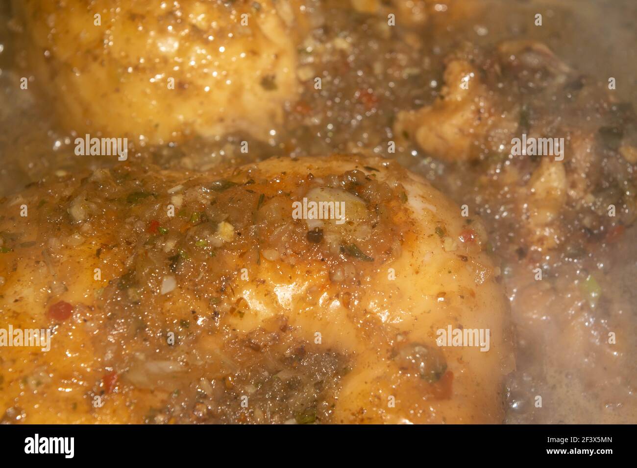 Kleine Stücke Hühnerfleisch werden mit Gewürzen geschmort. Nahaufnahme mit selektivem Fokus. Stockfoto