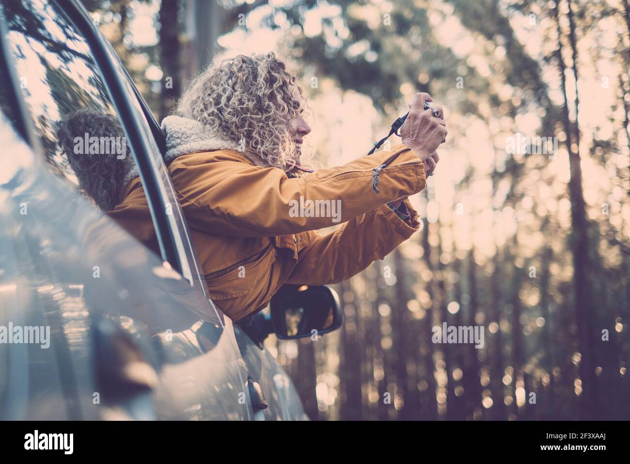 Abenteuerurlaub, Urlaub, Reise, Roadtrip und Menschen Konzept - glücklich lächelnd junge Erwachsene Frau oder junge Frau vor dem Autofenster unter Pictat Stockfoto