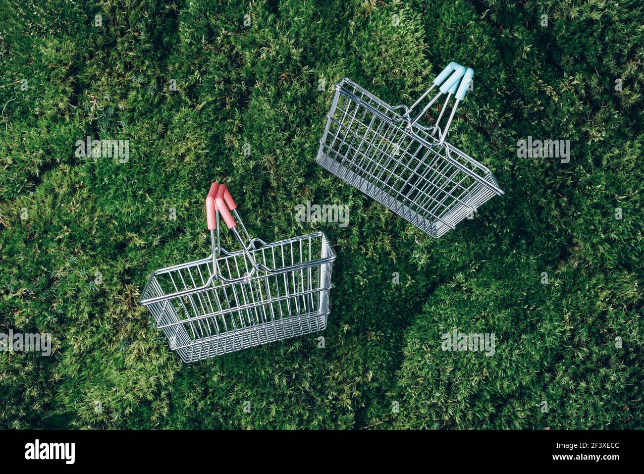 Nachhaltiger Lebensstil. Draufsicht auf Supermarkt-Warenkorb auf grünem Gras, Moos Hintergrund. Black friday Verkauf, Rabatt, shopaholism, Ökologie Stockfoto