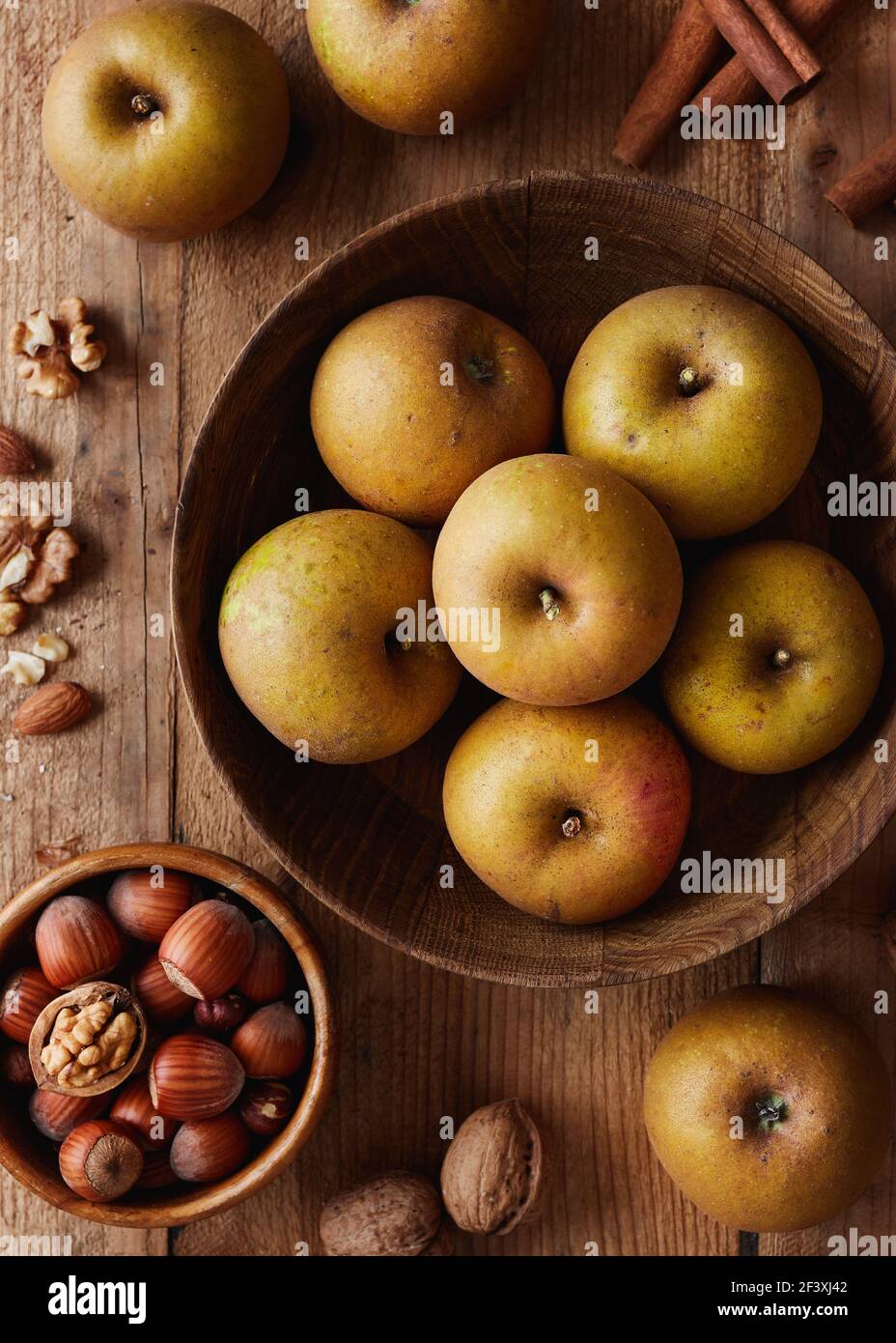 Herbstäpfel mit Nüssen und Zimtstangen auf Tisch, Draufsicht. Erbstück reinette Äpfel. Stockfoto