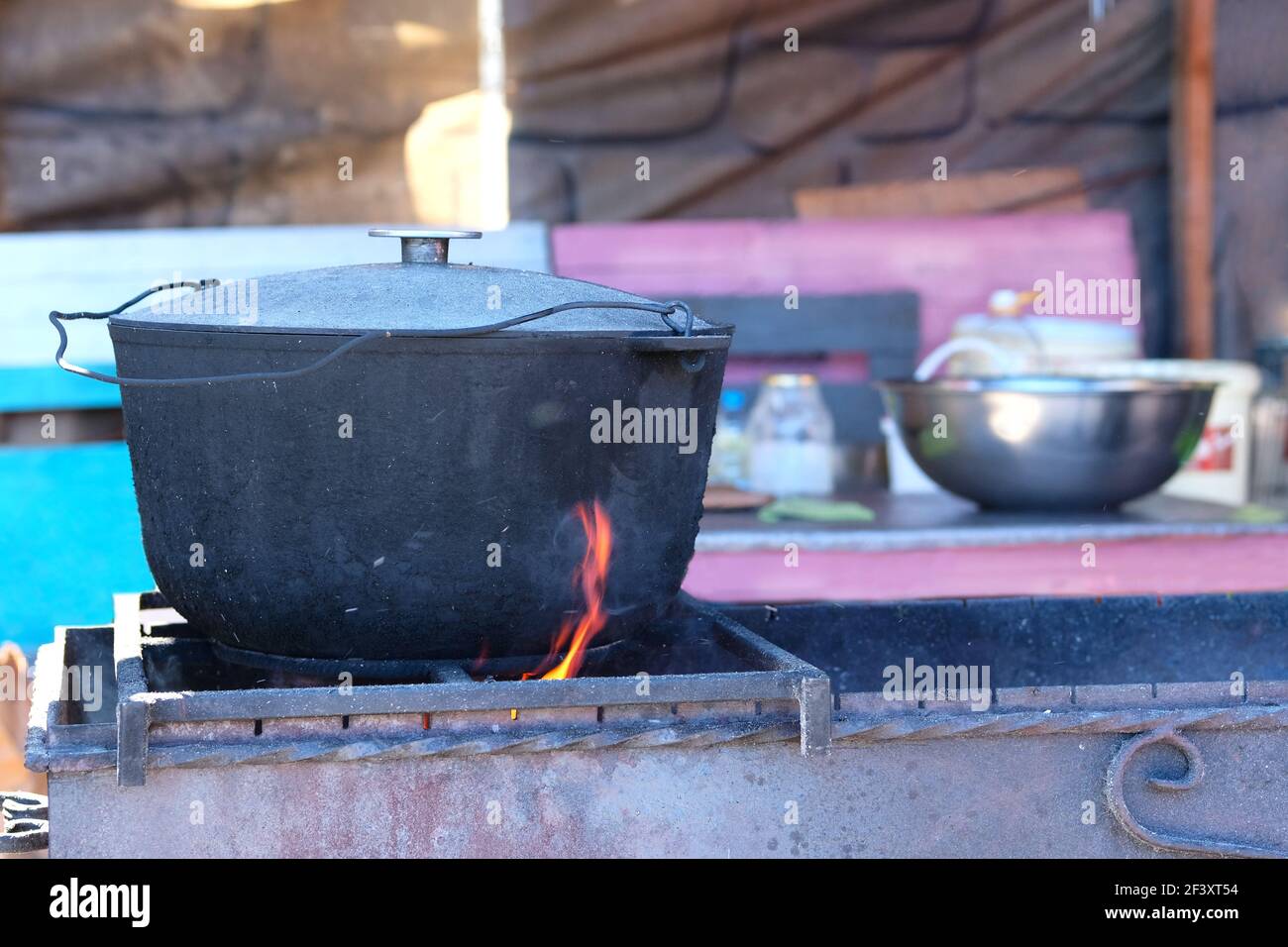 Essen kochen im Freien, offene Küche in Gusseisen Topf. Street Food BBQ. Stockfoto