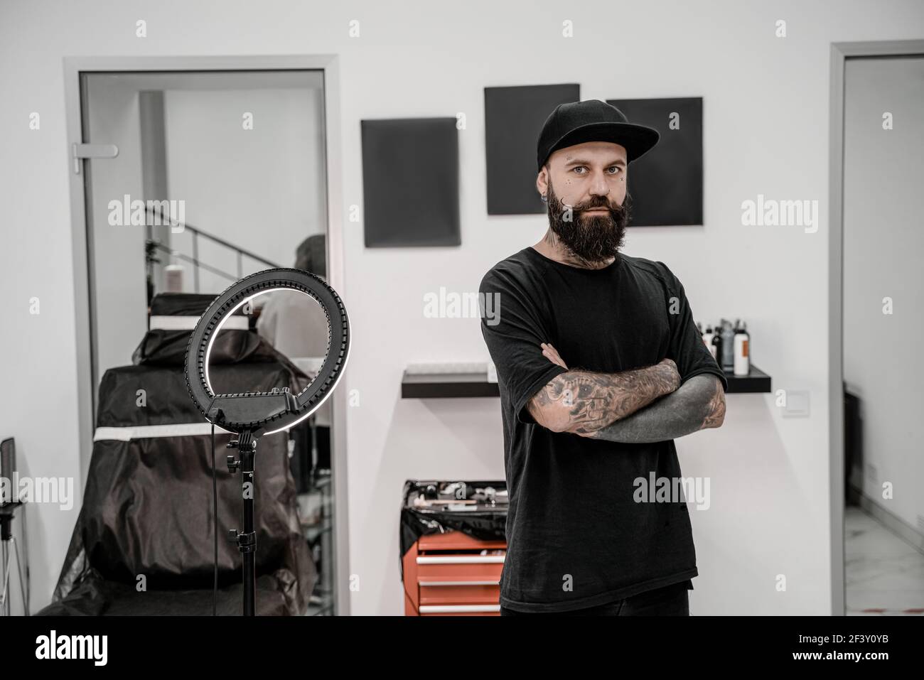 Junge männliche Tattoo-Künstler mit Bart positiv und glücklich stehend und lächelnd in Workshop-Platz. Stockfoto