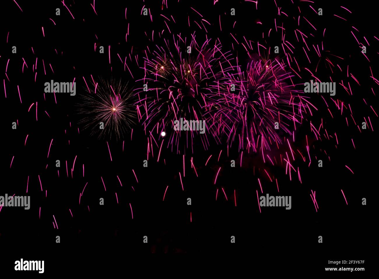 Vollmond umgeben von rosa und lila Feuerwerk Stockfoto