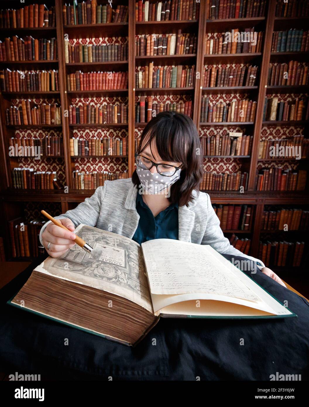 Die Sammlungsmanagerin Dr. Hannah Thomas mit einem Buch aus der historischen Bibliothek des ältesten lebenden Klosters Englands, Bar Convent in York, bereitet sich darauf vor, die seltene historisch bedeutsame Bibliothek der Welt zu enthüllen. Bilddatum: Donnerstag, 18. März 2021. Stockfoto