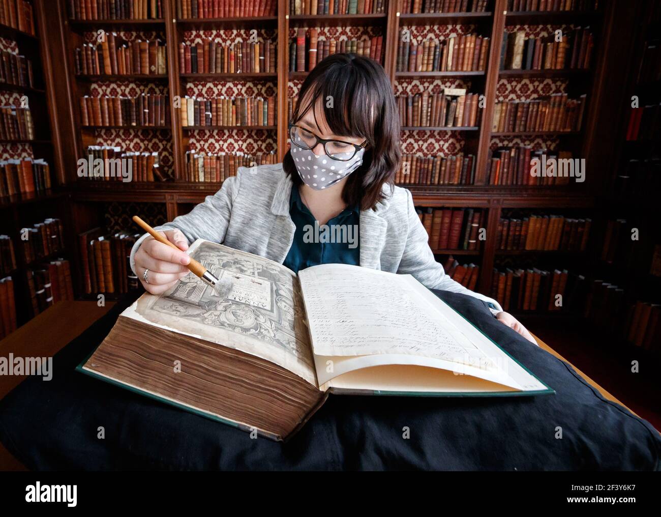 Die Sammlungsmanagerin Dr. Hannah Thomas mit einem Buch aus der historischen Bibliothek des ältesten lebenden Klosters Englands, Bar Convent in York, bereitet sich darauf vor, die seltene historisch bedeutsame Bibliothek der Welt zu enthüllen. Bilddatum: Donnerstag, 18. März 2021. Stockfoto