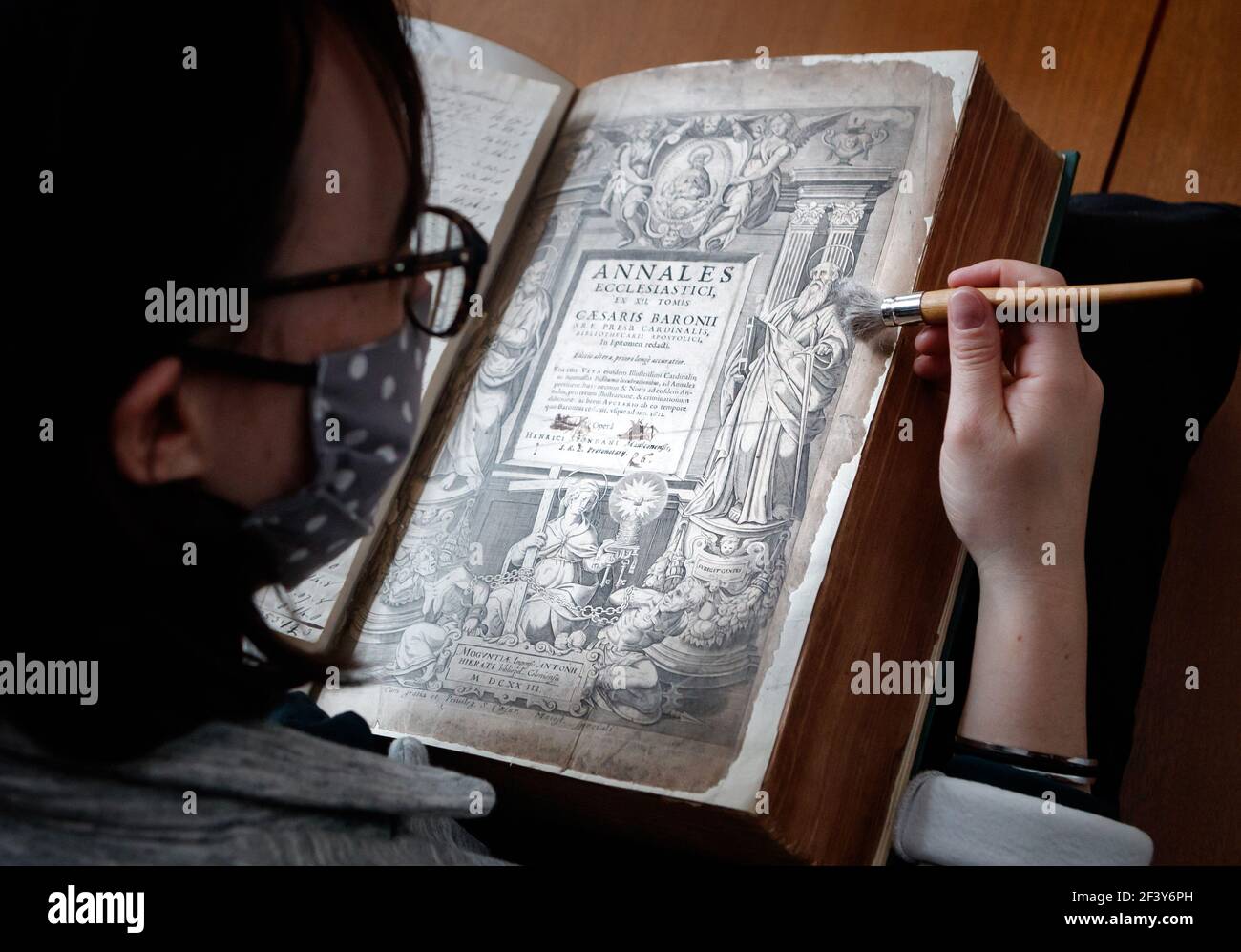 Die Sammlungsmanagerin Dr. Hannah Thomas mit einem Buch aus der historischen Bibliothek des ältesten lebenden Klosters Englands, Bar Convent in York, bereitet sich darauf vor, die seltene historisch bedeutsame Bibliothek der Welt zu enthüllen. Bilddatum: Donnerstag, 18. März 2021. Stockfoto