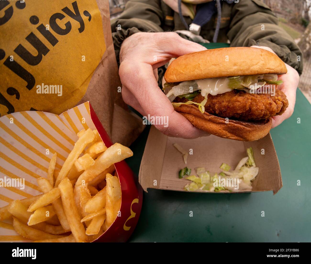 New York, USA. März 2021, 17th. Ein Diner bereitet das Mittagessen auf einem McDonald's Crispy Chicken Sandwich Deluxe zu, während er am Mittwoch, 17. März 2021, im Freien in New York zu Abend gegessen hat. Im Jahr 2019 Popeye's debütierte seine Huhn-Sandwich zu großem Erfolg führt fast jede Fast-Food-Kette zu einem knusprigen Huhn Menüelement zu generieren. McDonald's ist schließlich als 800-Pfund-Gorilla eingestiegen und hat bereits zu einer Steigerung des Fußgängerverkehrs in seinen Restaurants geführt. (ÂPhoto von Richard B. Levine) Quelle: SIPA USA/Alamy Live News Stockfoto