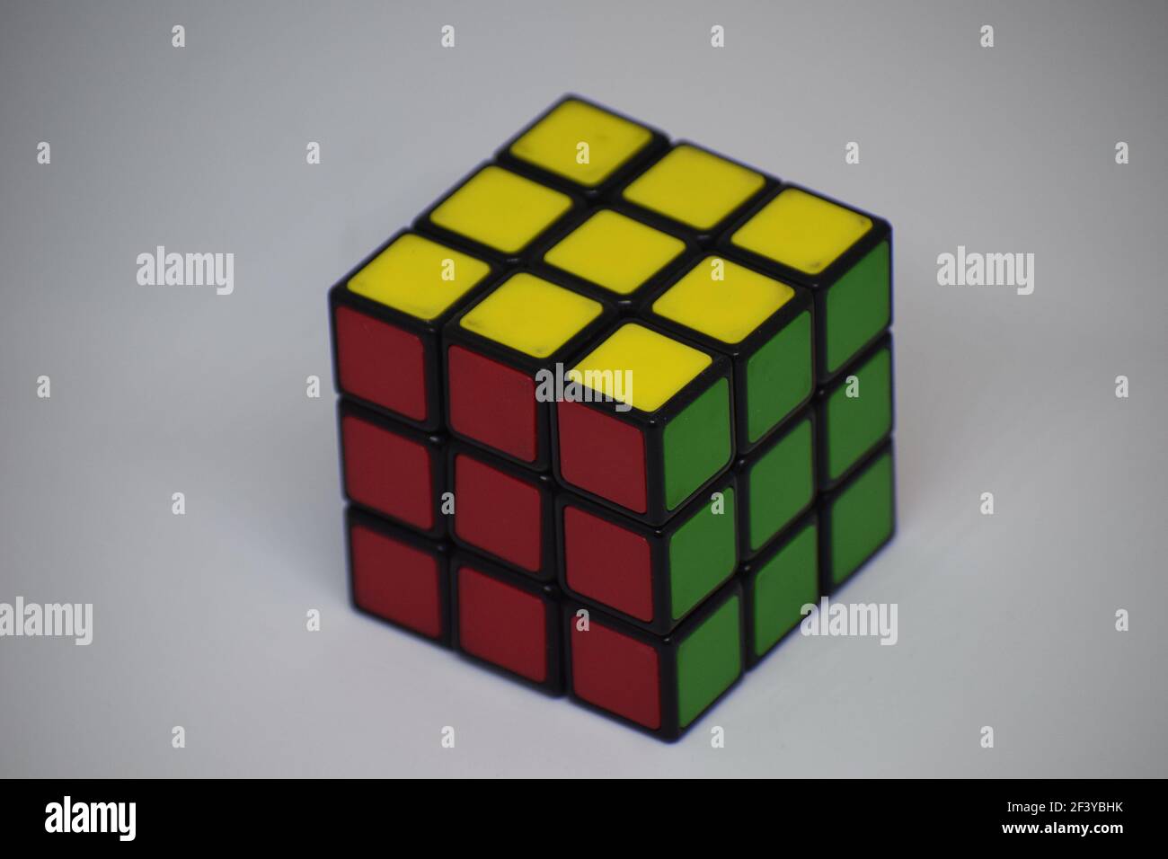 Ein gelöster Rubik-Würfel auf weißem Hintergrund Stockfoto