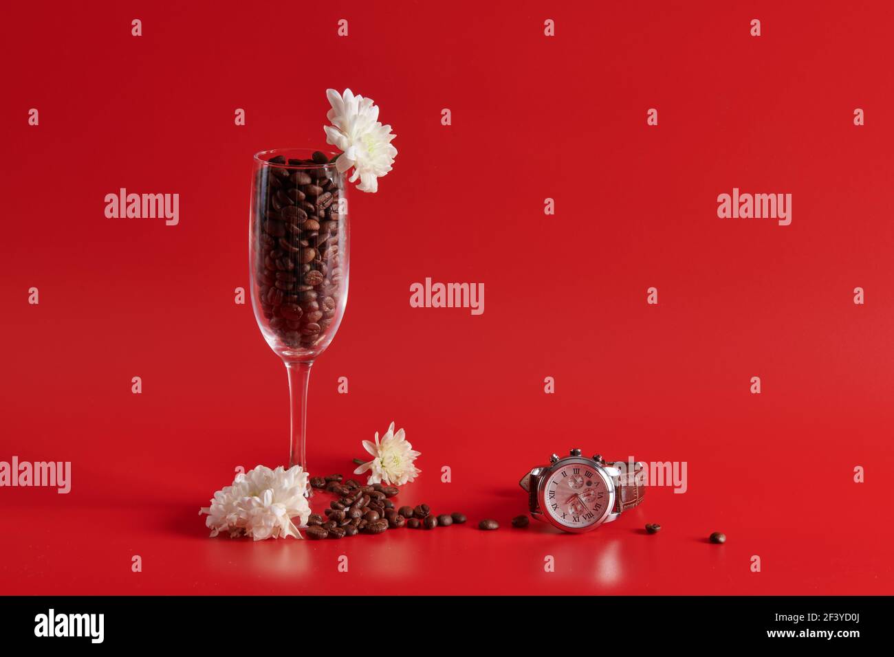 Uhr Weinglas und Kaffeebohnen auf rotem Hintergrund Stockfoto