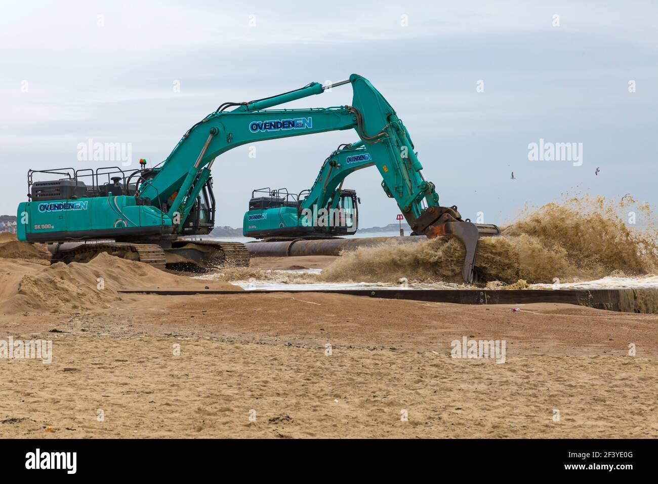 Bournemouth, Dorset, Großbritannien. März 2021, 18th. Am Strand von Bournemouth wird der Sand von einem Bagger durch Rohre aus dem Meer auf die Strandküste gepumpt. Mit mehr Menschen wahrscheinlich zu bleiben in diesem Jahr und Urlaub in Bournemouth die goldenen Sandstrände sind Teil der Attraktion. Ovenden SK500 Bagger - Wasser und Sand werden ausgepumpt und sprudeln. Quelle: Carolyn Jenkins/Alamy Live News Stockfoto