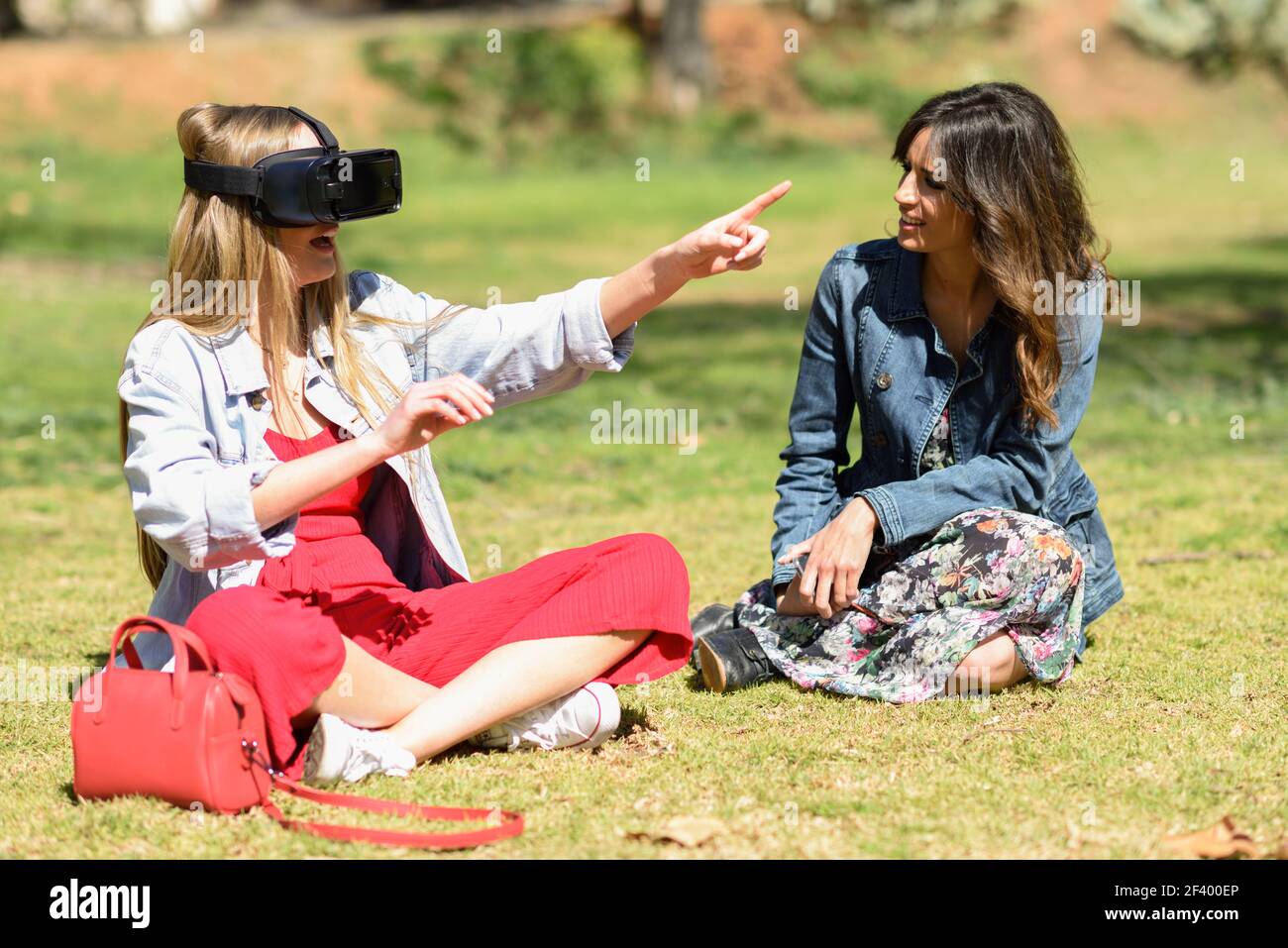 Zwei Frauen, die im VR-Brille und gestikulierte wild mit seinen Händen im Freien in städtischen Park Stockfoto