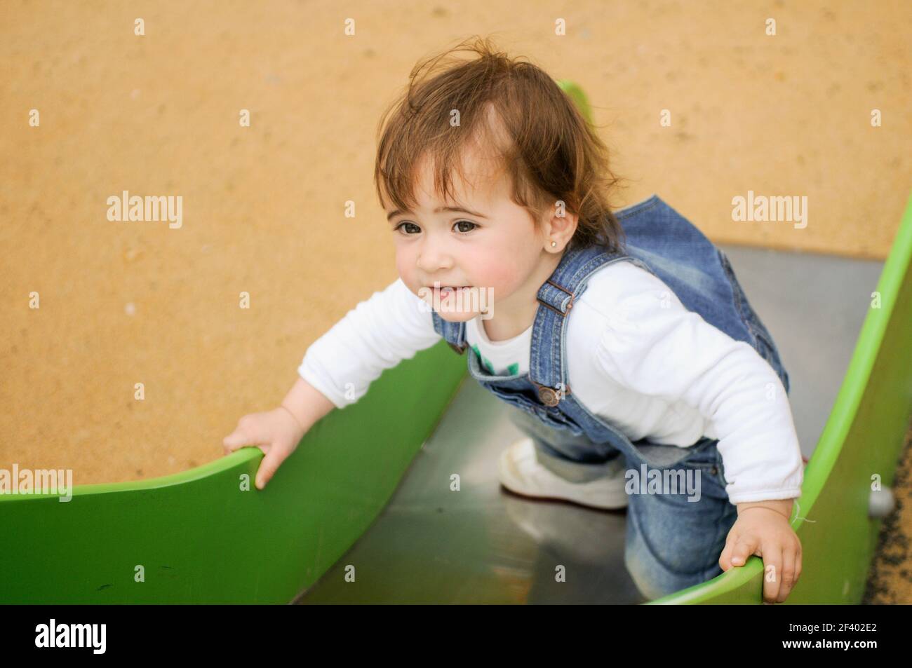 Gerne kleine Mädchen spielen in einem städtischen Spielplatz. Stockfoto