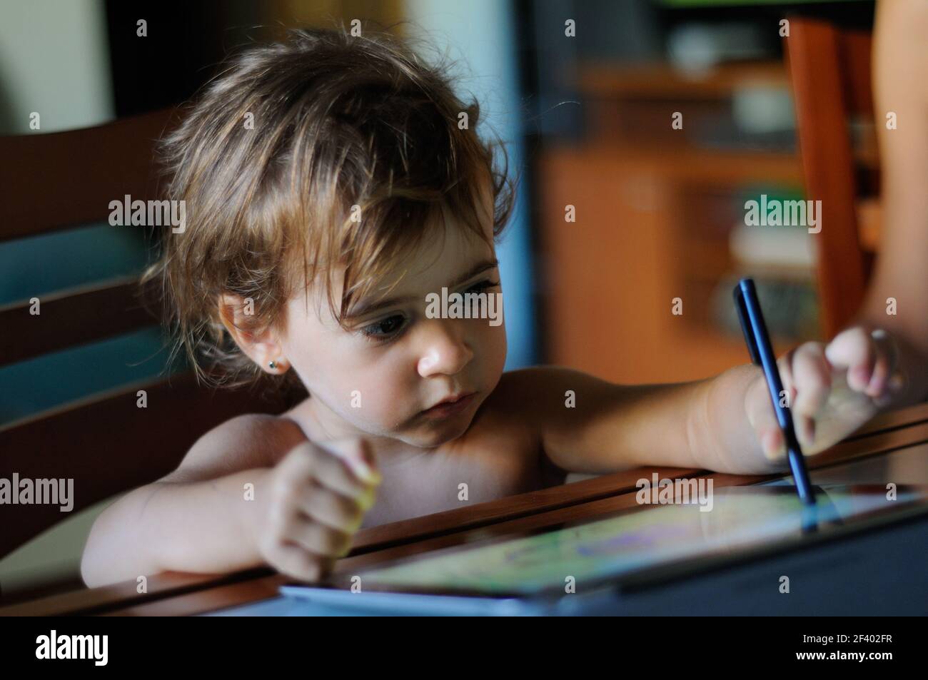 Kleines Mädchen, zwei Jahre alt, Malen mit einem digitalen Tablette zu Hause. Stockfoto