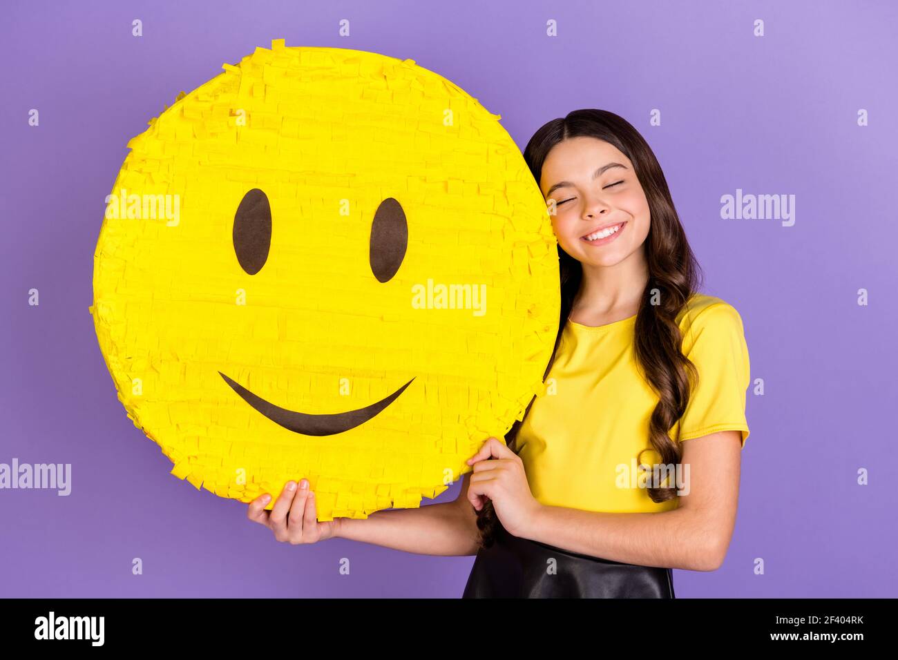 Foto von schönen optimistischen Brünette Frisur Mädchen halten Lächeln tragen Gelbes T-Shirt isoliert auf lebendigen lila Farbe Hintergrund Stockfoto