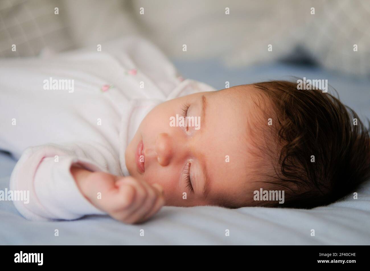 Neugeborene Mädchen auf blaue Blätter zu Hause schlafen Stockfoto