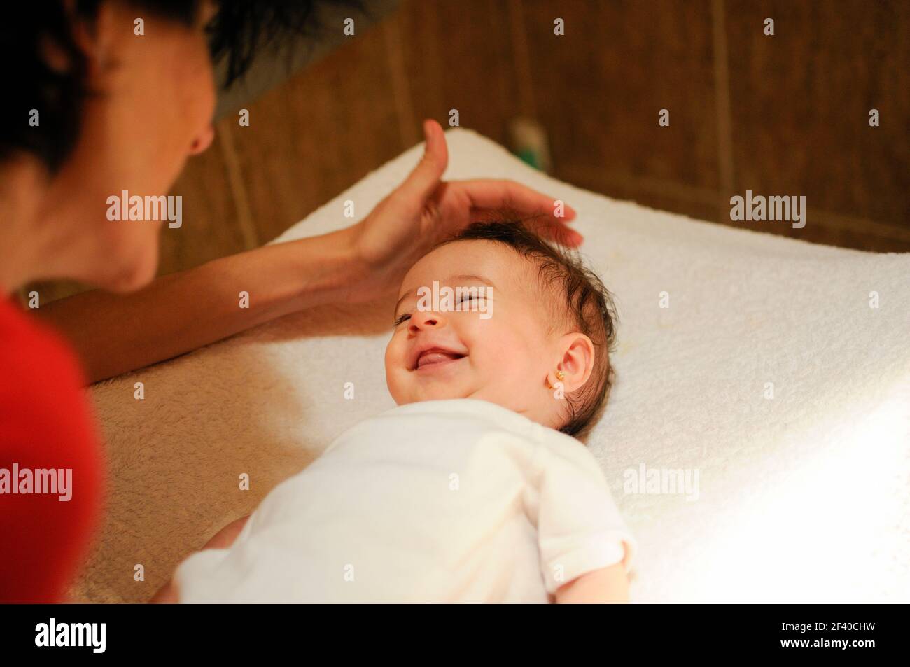 Baby Mädchen zwei Monate alt lächelnd zu ihrer Mutter zu Hause Stockfoto
