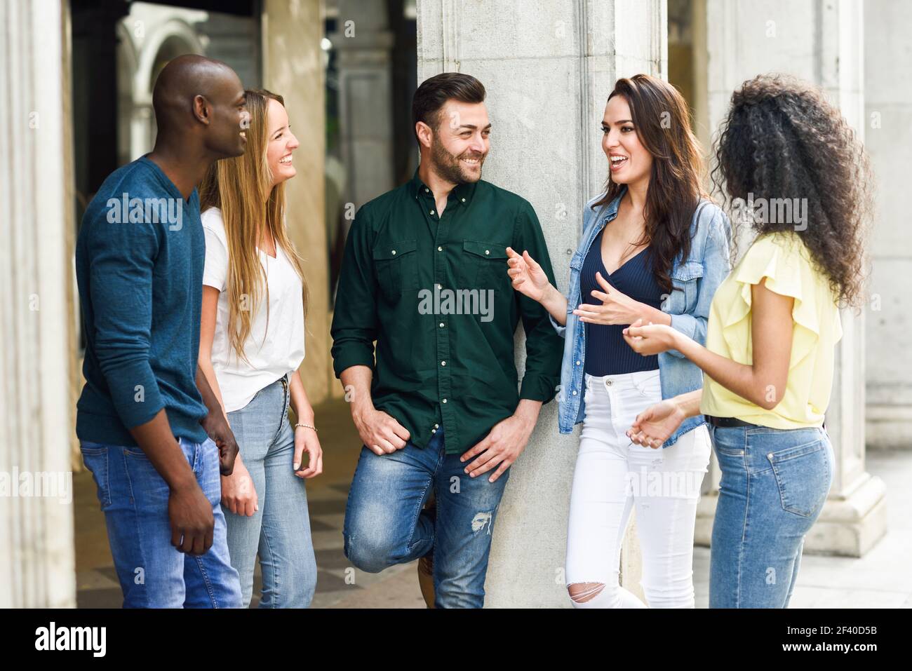 Multi-ethnischen Gruppe junger Leute, die gemeinsam Spaß im Freien im städtischen Hintergrund. Gruppe von schönen Frauen und Männer gemeinsam lachen Stockfoto