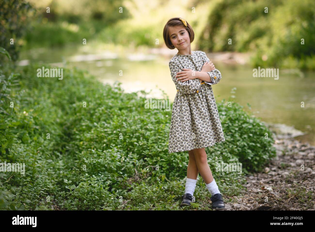 Kleine schöne Mädchen im Naturstrom trägt schönes Kleid. Kleines Mädchen im Naturstrom trägt schönes Kleid Stockfoto