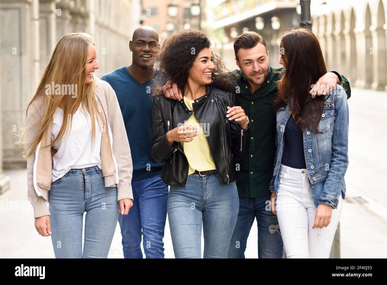 Multi-ethnische Gruppe von jungen Menschen, die Spaß zusammen im Freien im städtischen Hintergrund. Gruppe von Menschen zusammen zu Fuß. Gruppe von Freunden, die gemeinsam Spaß im Freien haben Stockfoto