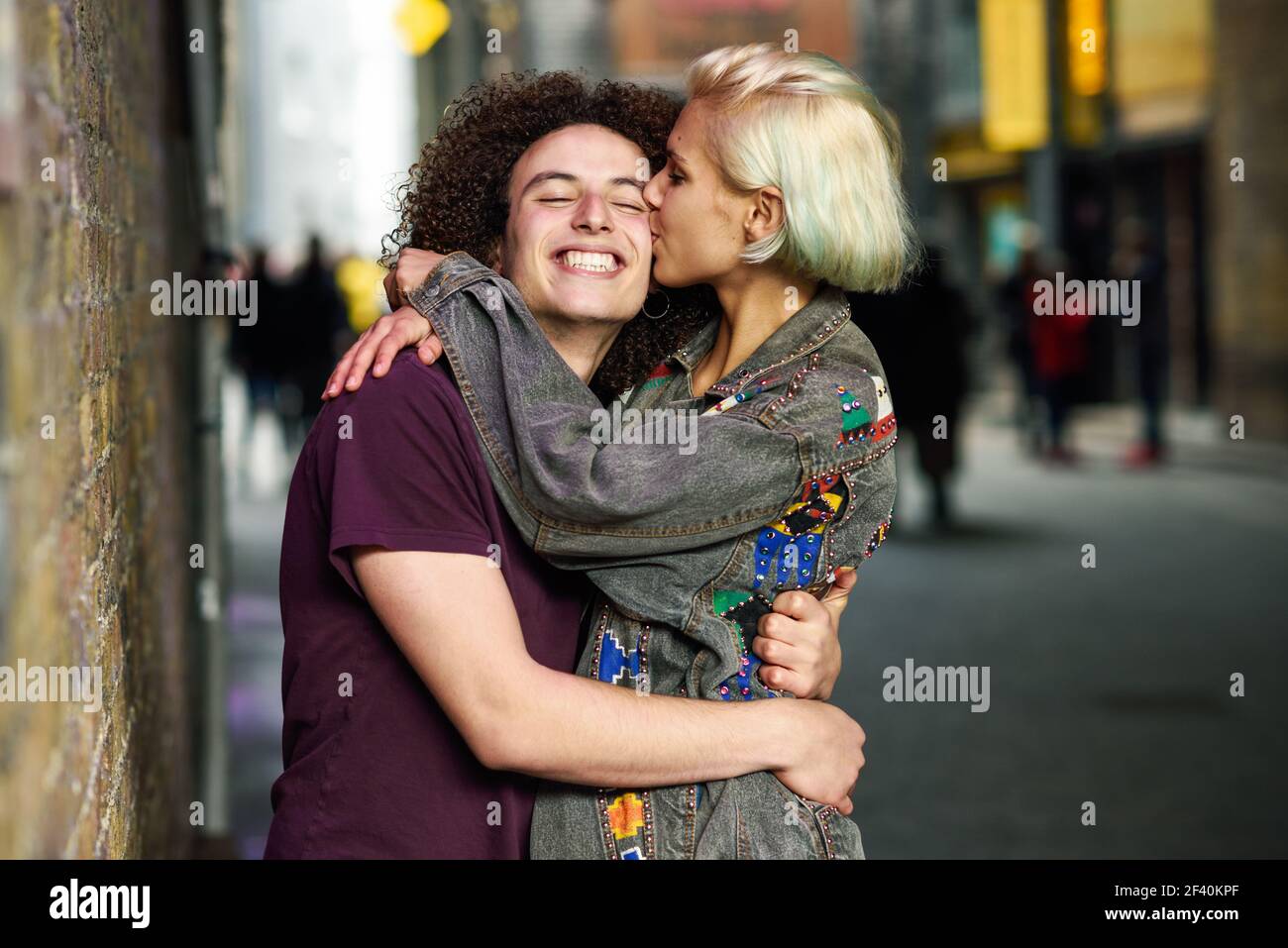 Glückliches Paar umarmt im städtischen Hintergrund auf einer typischen Londoner Straße. GROSSBRITANNIEN... Junges Paar umarmt im städtischen Hintergrund auf einer typischen Londoner Straße. Stockfoto