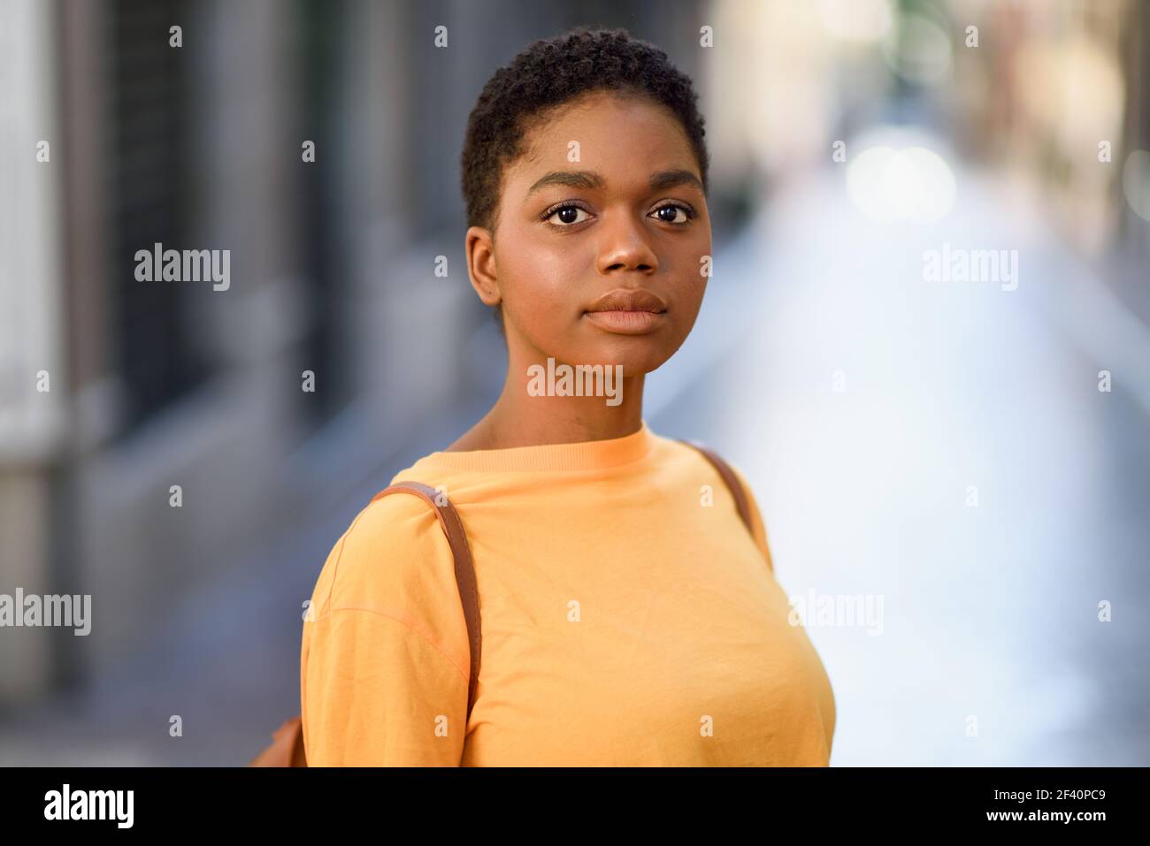 Junge afrikanische Frau trägt Freizeitkleidung Blick auf Kamera. Mädchen mit sehr kurzen Haaren.. Junge afrikanische Frau trägt Freizeitkleidung Blick auf Kamera. Stockfoto