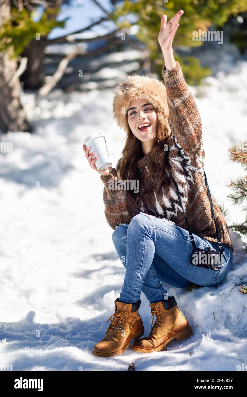 Frau trägt Winterkleidung trinken heißen Kaffee. Junge Frau genießen die verschneiten Berge im Winter, in Sierra Nevada, Granada, Spanien.. Junge Frau genießt die verschneiten Berge im Winter Stockfoto